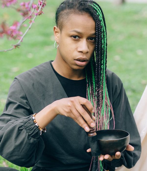 Woman in a peaceful yoga pose, surrounded by emerald green colors.